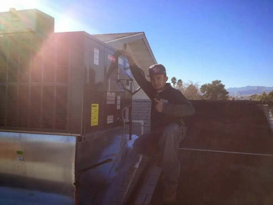 HVAC technician performing AC Tune-Up on a rooftop unit in Chubbuck